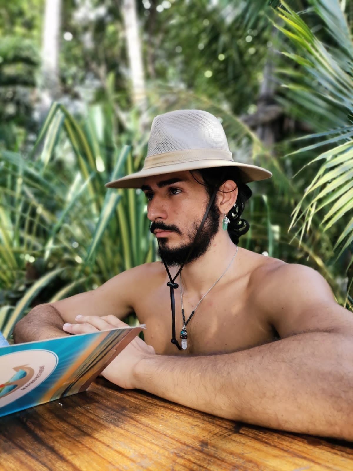 Foto de Matias con sombrero sentado viendo un libro